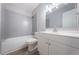 Updated bathroom featuring modern gray subway tiles, a bathtub, and a sleek white vanity at 4807 Wynwood Dr, Tampa, FL 33615