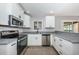 Modern kitchen featuring white cabinets, stainless steel appliances, and granite countertops, perfect for cooking at 4807 Wynwood Dr, Tampa, FL 33615