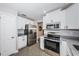 Modern kitchen featuring stainless steel appliances, granite countertops, and bright white cabinetry at 4807 Wynwood Dr, Tampa, FL 33615