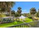 Backyard view of canal, covered area, dock, and lush landscaping from the balcony at 58 Inness Dr, Tarpon Springs, FL 34689