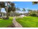 Inviting backyard features lush lawn, brick pathway, and lovely view of the canal at 58 Inness Dr, Tarpon Springs, FL 34689