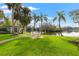 Backyard view of canal, covered area, dock, and lush landscaping from the yard at 58 Inness Dr, Tarpon Springs, FL 34689