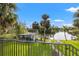 Backyard view of canal, covered area, dock, and lush landscaping from the balcony at 58 Inness Dr, Tarpon Springs, FL 34689