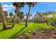 Backyard view of canal, covered area, dock, and lush landscaping from the yard at 58 Inness Dr, Tarpon Springs, FL 34689