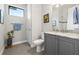 Contemporary bathroom with gray vanity, granite countertop, hexagon tile floor, and a shower with glass door at 58 Inness Dr, Tarpon Springs, FL 34689