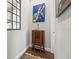 Hallway showcasing an antique radio cabinet and hardwood floors below a modern art print at 58 Inness Dr, Tarpon Springs, FL 34689