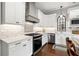 Modern kitchen featuring white cabinetry, stainless steel appliances, and a gas cooktop beneath a modern hood at 58 Inness Dr, Tarpon Springs, FL 34689