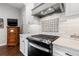 Modern kitchen featuring a gas range, white subway tile backsplash, and stainless steel appliances at 58 Inness Dr, Tarpon Springs, FL 34689