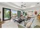 Bright living room featuring sliding glass doors to the outdoor patio, plush seating, and a ceiling fan at 58 Inness Dr, Tarpon Springs, FL 34689