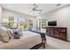 Bright main bedroom featuring a ceiling fan, balcony access, and views of swaying palms trees at 58 Inness Dr, Tarpon Springs, FL 34689