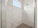 New shower with floor-to-ceiling marble tiles and a window allowing natural light at 58 Inness Dr, Tarpon Springs, FL 34689