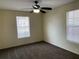 This bedroom features carpet, neutral walls, a ceiling fan, and a double-hung window at 5924 Brickleberry Ln # 101, Zephyrhills, FL 33541