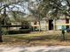 Exterior view of a building with carports and well-maintained lawns, showcasing community landscaping at 5924 Brickleberry Ln # 101, Zephyrhills, FL 33541