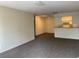 Open living room with gray carpeting, neutral paint and open view into the kitchen at 5924 Brickleberry Ln # 101, Zephyrhills, FL 33541