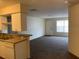 Cozy living room featuring neutral carpet, white walls, and a kitchen pass-through at 5924 Brickleberry Ln # 101, Zephyrhills, FL 33541