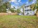 Large grassy backyard with two story home, shed, and wooden fence at 605 12Th N Ave, St Petersburg, FL 33701