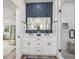 Bathroom with dual sink vanity, blue accent wall, and a glass-enclosed shower at 605 12Th N Ave, St Petersburg, FL 33701