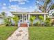 Inviting home exterior with a screened porch, freshly painted and enhanced by vibrant, well-manicured landscaping at 605 12Th N Ave, St Petersburg, FL 33701