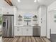 Bright kitchen featuring stainless steel refrigerator, white cabinets, and view from window at 605 12Th N Ave, St Petersburg, FL 33701