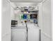 Organized laundry room with shelving, washer, and dryer behind shutter doors at 605 12Th N Ave, St Petersburg, FL 33701