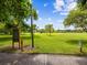 Expansive green park with mature trees, walking path, and clear signage on a sunny day with blue skies at 605 12Th N Ave, St Petersburg, FL 33701