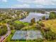 Aerial shot showcases tennis courts next to a lake, surrounded by lush trees, greenery and neighborhood at 605 12Th N Ave, St Petersburg, FL 33701