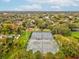 Aerial view highlighting tennis courts nestled among trees and greenery within a residential neighborhood at 605 12Th N Ave, St Petersburg, FL 33701