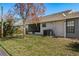 Backyard featuring green grass, a shade tree, and the side of the house at 7536 Roland Ct, New Port Richey, FL 34654