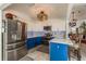 Modern kitchen with white and blue cabinets, stainless steel appliances, quartz counters and a tiled backsplash at 7536 Roland Ct, New Port Richey, FL 34654