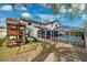 Spacious backyard featuring a wooden playset and screened pool, perfect for outdoor living at 759 Timuquana Ln, Palm Harbor, FL 34683