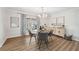 Cozy dining area featuring a round table, stylish chairs, modern lighting, and a view of the outdoors through a large window at 759 Timuquana Ln, Palm Harbor, FL 34683