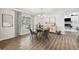 Cozy dining area featuring a round table, stylish chairs, modern lighting, and a view of the outdoors through a large window at 759 Timuquana Ln, Palm Harbor, FL 34683