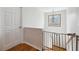 This hallway features hardwood floors, a window, and a safety gate at 759 Timuquana Ln, Palm Harbor, FL 34683