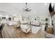 This well-lit living room features an open concept, wood floors, fireplace, and a fan on the vaulted ceiling at 759 Timuquana Ln, Palm Harbor, FL 34683