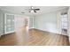 Bright living room with wood-look flooring, large windows dressed with white curtains, and glass doors to the foyer at 759 Timuquana Ln, Palm Harbor, FL 34683