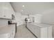 Well-lit kitchen featuring white cabinetry, modern appliances and large island at 8363 Sandbank Pl, Englewood, FL 34224