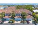 Aerial view of townhomes featuring a red tile roof, garages, mature landscaping, and nearby parking at 903 Pinellas Bayway S # 307, Tierra Verde, FL 33715