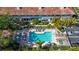 Aerial view of a community pool and hot tub surrounded by lush mature trees and lounge chairs at 903 Pinellas Bayway S # 307, Tierra Verde, FL 33715