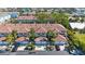 Aerial view of townhomes featuring a red tile roof, garages, mature landscaping, and nearby parking at 903 Pinellas Bayway S # 307, Tierra Verde, FL 33715