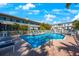 Community pool with lounge chairs surrounded by lush tropical landscaping and clear blue water at 903 Pinellas Bayway S # 307, Tierra Verde, FL 33715