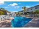 Community pool with clear blue water and lounge chairs surrounded by lush tropical landscaping at 903 Pinellas Bayway S # 307, Tierra Verde, FL 33715