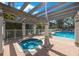 Community pool with clear blue water and lounge chairs surrounded by lush tropical landscaping at 903 Pinellas Bayway S # 307, Tierra Verde, FL 33715