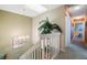 Upstairs hallway features decorative chandelier, carpet floors and stairway with white railings at 903 Pinellas Bayway S # 307, Tierra Verde, FL 33715