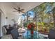 Screened patio with wicker furniture offers views of landscaped backyard at 903 Pinellas Bayway S # 307, Tierra Verde, FL 33715