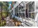 Bright screened porch with steps and paver pathway, open to the beautiful tropical foliage at 903 Pinellas Bayway S # 307, Tierra Verde, FL 33715