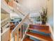 View of beautiful staircase with wood steps and white railings leading to the main floor living area at 903 Pinellas Bayway S # 307, Tierra Verde, FL 33715