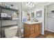 Bathroom with wooden vanity, large mirror and utility shelf with toilet at 9234 Duffer Ct, Hudson, FL 34667