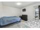 Well-lit bedroom featuring a blue bedspread, dresser, TV, and white baby changing table with a window view at 9234 Duffer Ct, Hudson, FL 34667