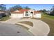 Charming single-story home featuring a three-car garage, light exterior paint, and red roof at 9234 Duffer Ct, Hudson, FL 34667