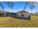 Rear exterior view highlighting backyard, featuring a covered pool area and well-maintained lawn at 9234 Duffer Ct, Hudson, FL 34667